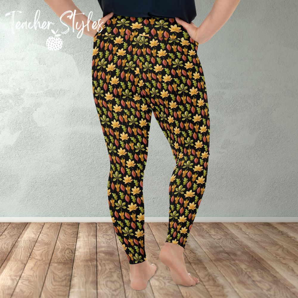 Autumn Leaves plus size leggings - black by Teacher Styles. Model is shown from the waist down. Leggings have black background and pattern of yellow maple, green oak and red elm leaves. back view