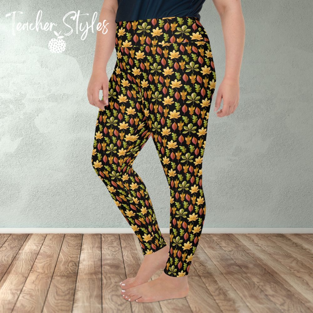 Autumn Leaves plus size leggings - black by Teacher Styles. Model is shown from the waist down. Leggings have black background and pattern of yellow maple, green oak and red elm leaves. side view