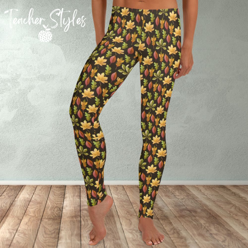 Autumn Leaves leggings - brown by Teacher Styles. Model is shown from the waist down. Leggings have brown background and pattern of yellow maple, green oak and red elm leaves. front view