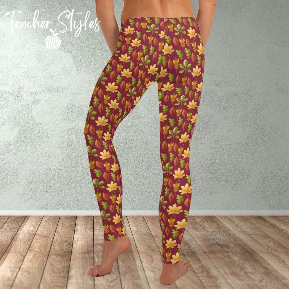 Autumn Leaves leggings - burgundy by Teacher Styles. Model is shown from the waist down. Leggings have burgundy background and pattern of yellow maple, green oak and red elm leaves. back view