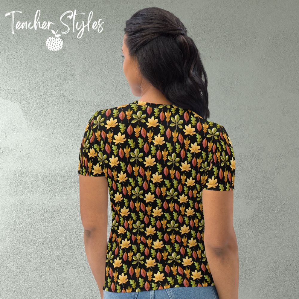 Autumn Leaves t-shirt - black by Teacher Styles. Model is shown from the waist up .T-shirt has a black background and pattern of yellow maple, green oak and red elm leaves. back view