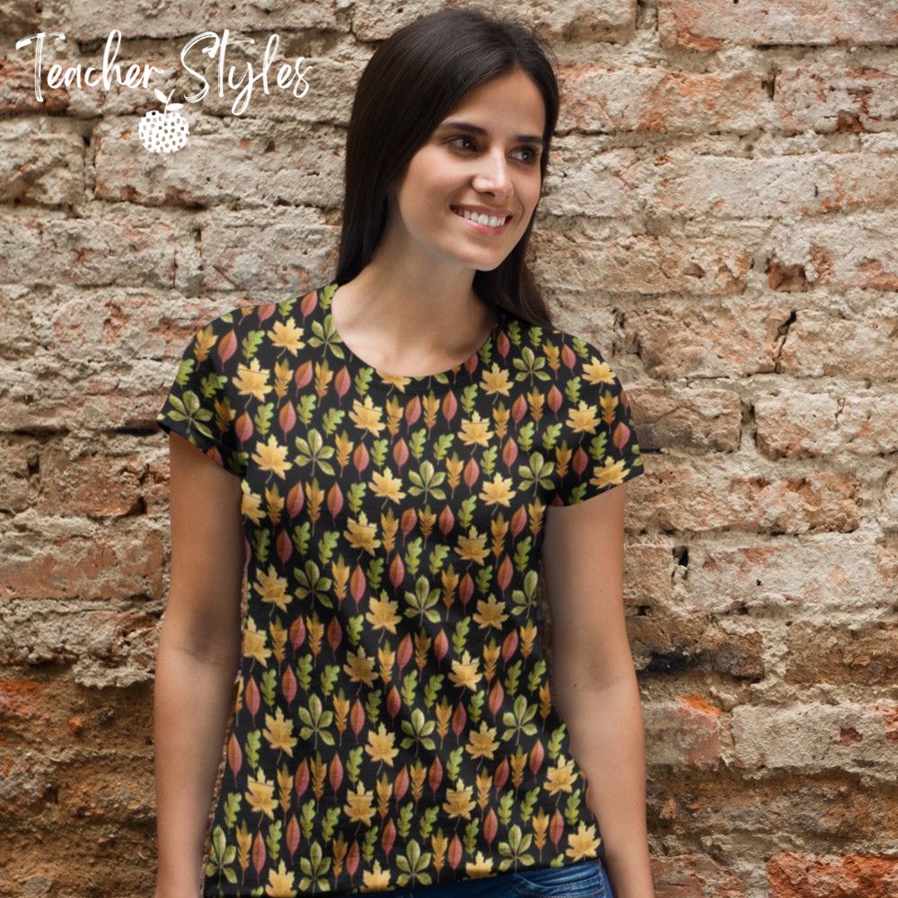 Autumn Leaves t-shirt - black by Teacher Styles. Model is shown from the waist up .T-shirt has a black background and pattern of yellow maple, green oak and red elm leaves.  lifestyle shot