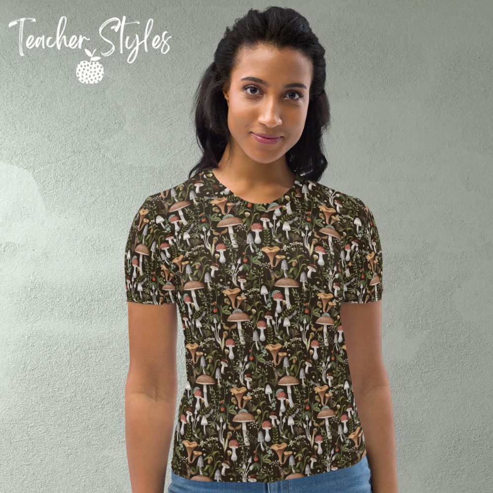 Fungi Fun T-shirt - brown by Teacher Styles. Model is shown from the waist up. T-shirt has brown background and pattern of forest mushrooms. front view