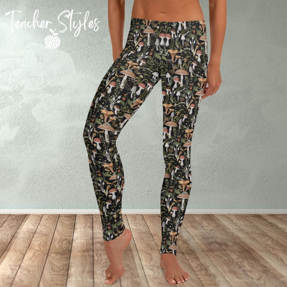 Fungi Fun leggings - black by Teacher Styles. Model is shown from the waist down. Leggings have black background and pattern of forest mushrooms.  front view