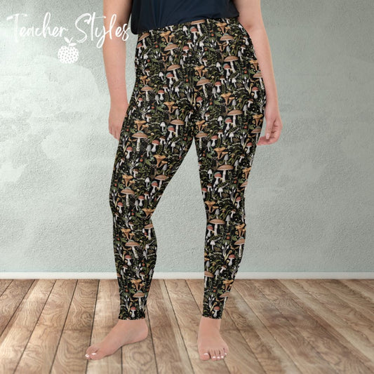 Fungi Fun plus size leggings - black by Teacher Styles. Model is shown from the waist down. Leggings have black background and pattern of forest mushrooms.  front view