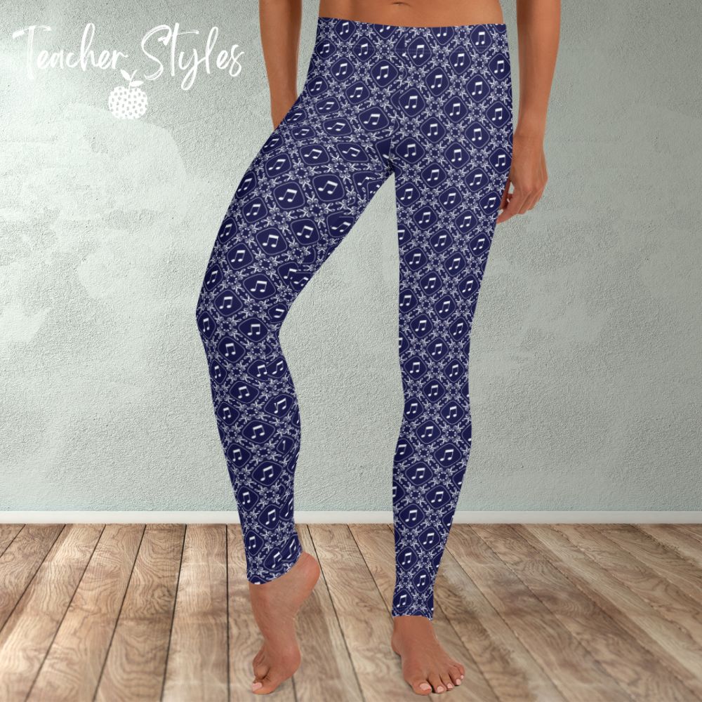 Musical Interlude leggings by Teacher Syles. Model is shown from the waist down.  Leggings have deep blue background with white lattice pattern made of treble clefs. Musical notes in each treble square. front view