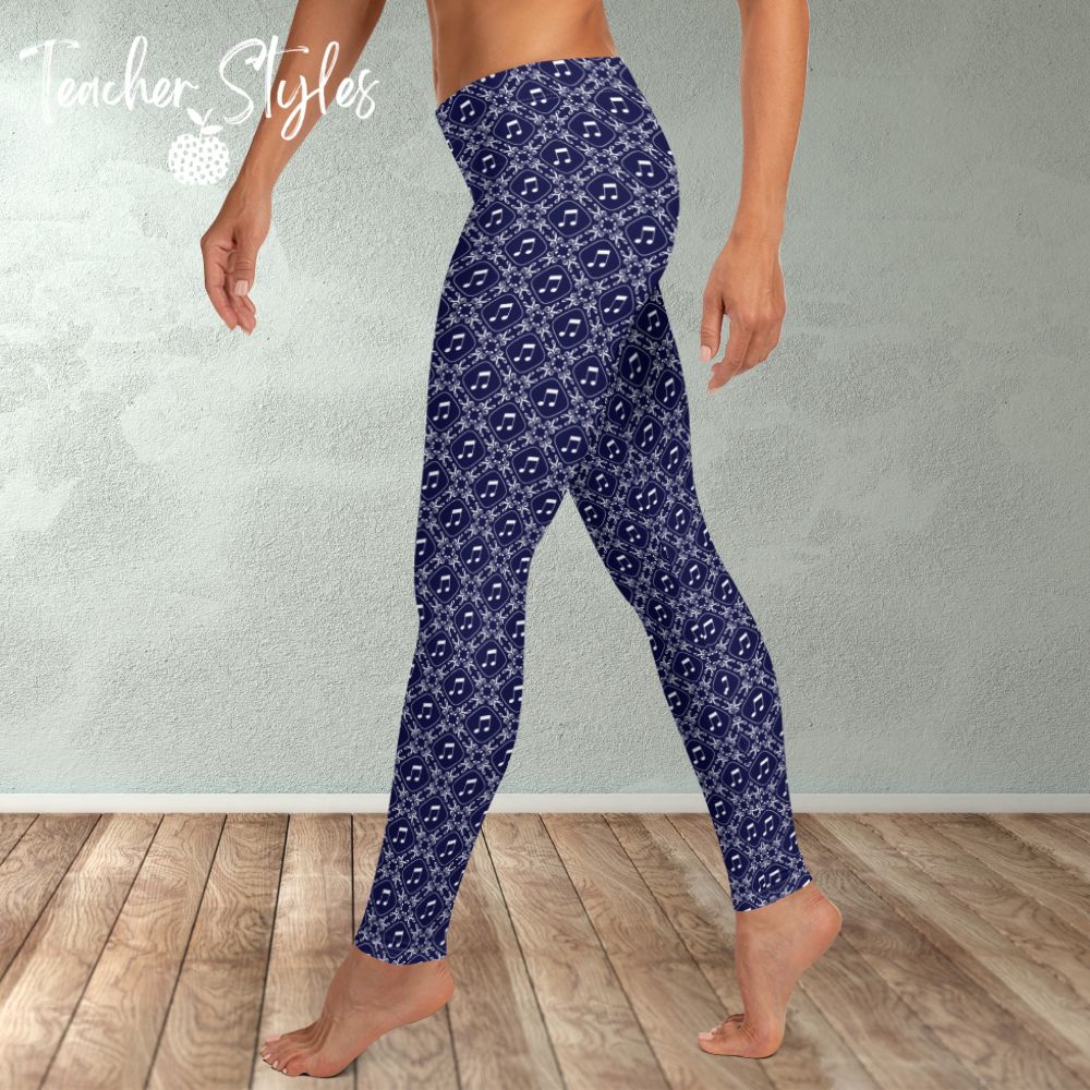 Musical Interlude leggings by Teacher Syles. Model is shown from the waist down.  Leggings have deep blue background with white lattice pattern made of treble clefs. Musical notes in each treble square. side  view