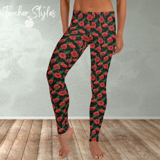 Poppies - black leggings by Teacher Styles. Model shown from the waist down. Leggings have black background with vibrant red poppies and greenery.  Front view. Also suitable for National Poppy Day, Armistice Day, Remembrance Day.