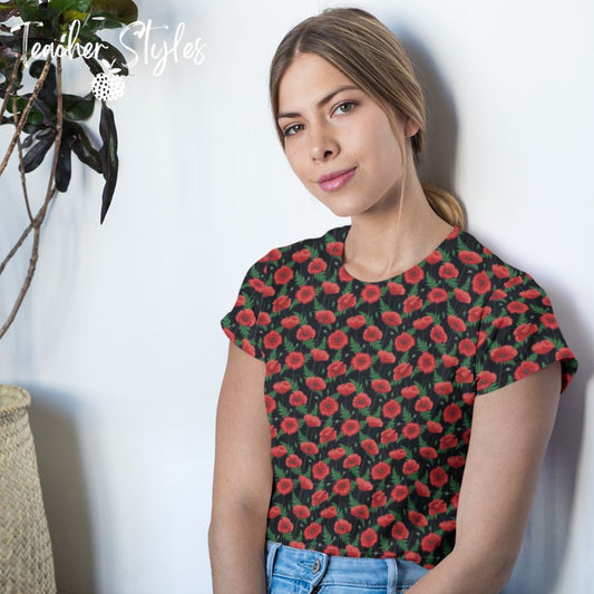 Poppies - black T-shirt by Teacher Styles. Model shown from the waist up.  T-shirt has black background with pattern of red poppies and greenery. Beautiful floral top perfect for Remembrance Day, Armistice Day and National Poppy Day. Lifestyle shot.