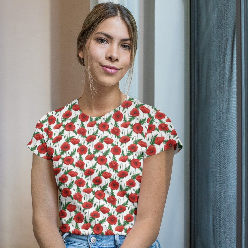 Poppies T-shirt - white by Teacher Styles. Model shown from the waist up.  T-shirt has white background with pattern of red poppies and greenery. Beautiful floral top perfect for Remembrance Day, Armistice Day and National Poppy Day. Front view