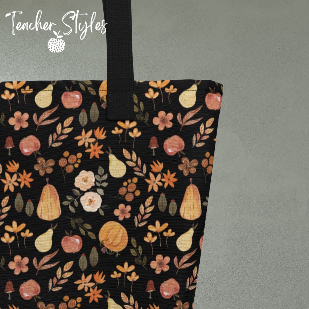 Stitch detail  of Fall Fun tote bag by Teacher Styles. Print is black background with pattern of pumpkins, apples, pears and flowers. Black webbed handles. 