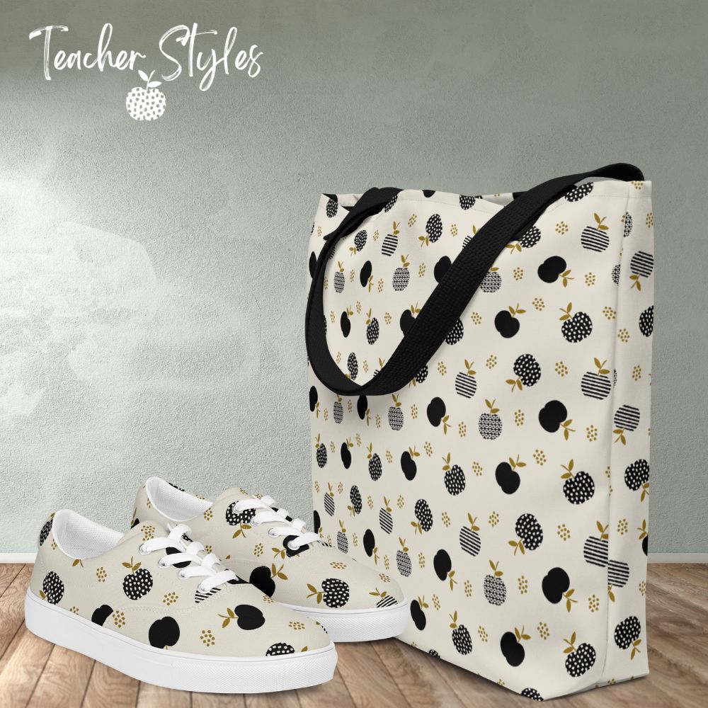 Modern Apple Tote with matching Modern Apple lace-up canvas shoes by Teacher Styles. Tote and shoes are off white with black apples in solids, stripes and dots. Black canvas web handles on tote. Tote and shoes are on table.