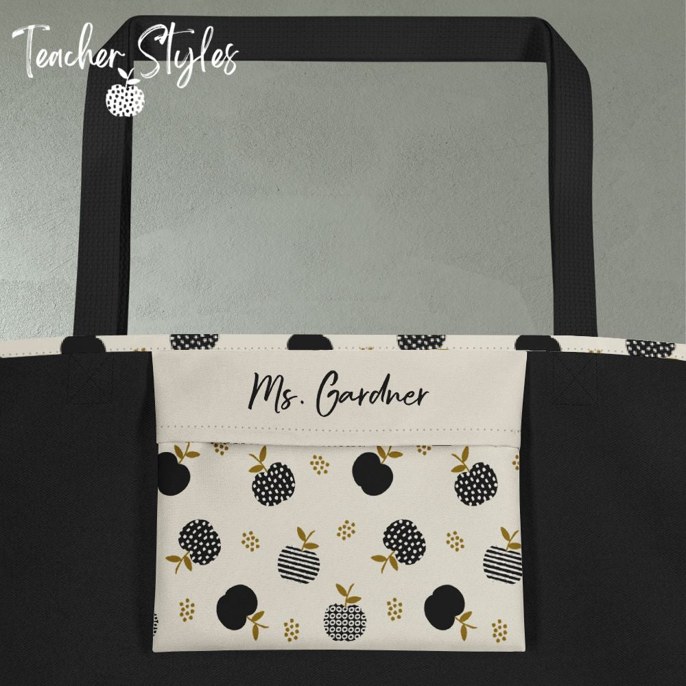 Close up of tote inner pocket. Black interior. Pocket covered in Modern Apple print. Custom personalization shown with name "Ms. Gardner" on pocket in black script