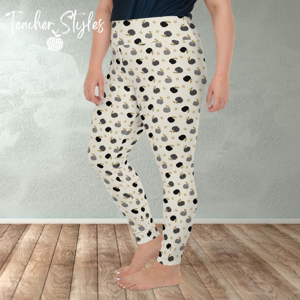 Modern Apple Plus Size Leggings by Teacher Styles. Image of woman from the waist down in room wearing leggings. Side view. Comfortable and stylish light beige/cream leggings featuring a pattern of black apples in solids, stripes and dots.  